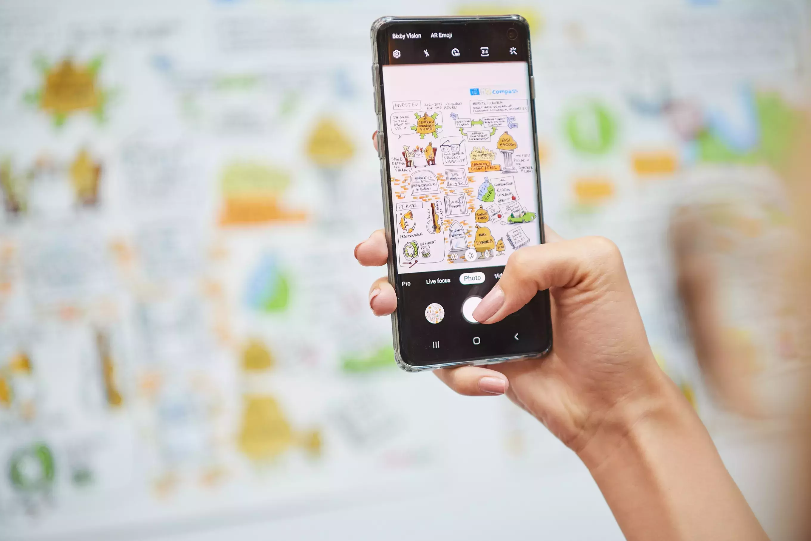 Event participant taking a photo of illustrations