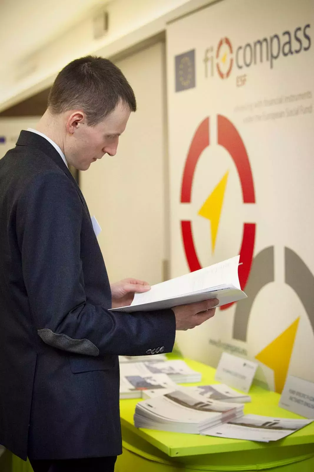 Event participant reading a fi-compass publication