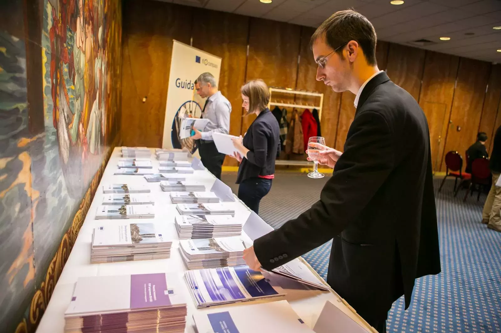 Event participant looking at fi-compass publications