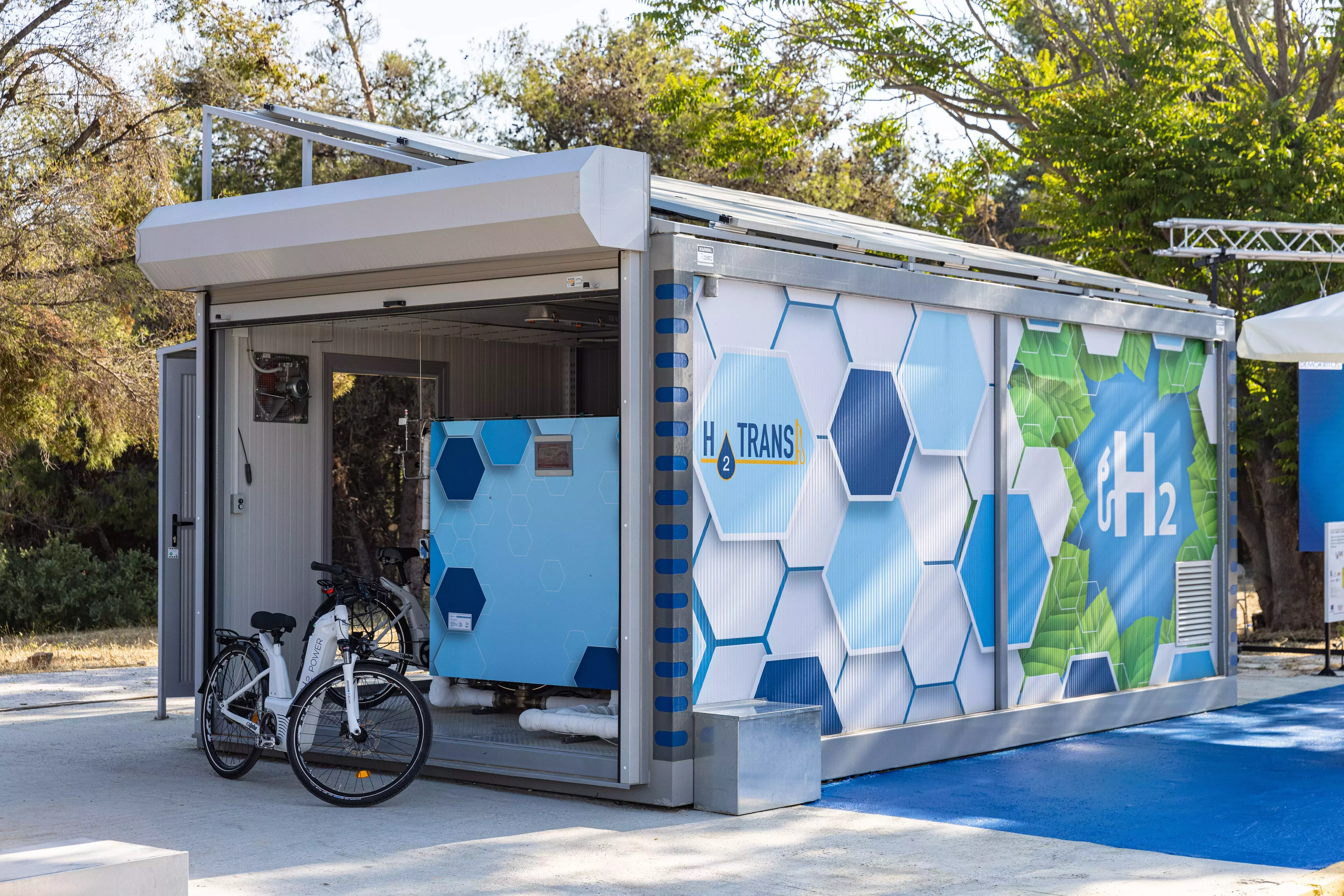 The Hydrogen Refuelling Station (HRS) with a view on the CYRUS compressor in it (the smaller light blue box). The Hydrogen Refuelling Station (HRS) with a view on the CYRUS compressor in it (the smaller light blue box).