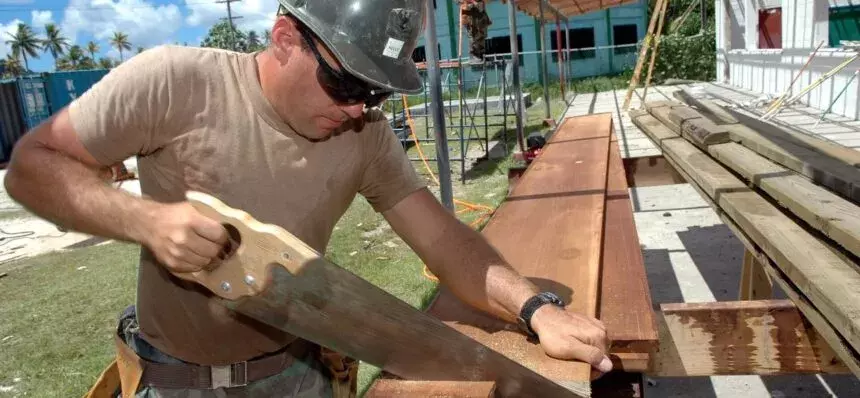 Man sawing wood on a construction site Man sawing wood on a construction site